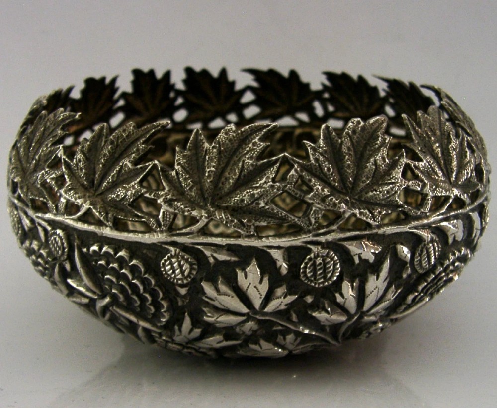 A rounded solid silver bowl featuring detailed repousse floral and foliate hand-chased decoration with a circular central polished medallion. View III