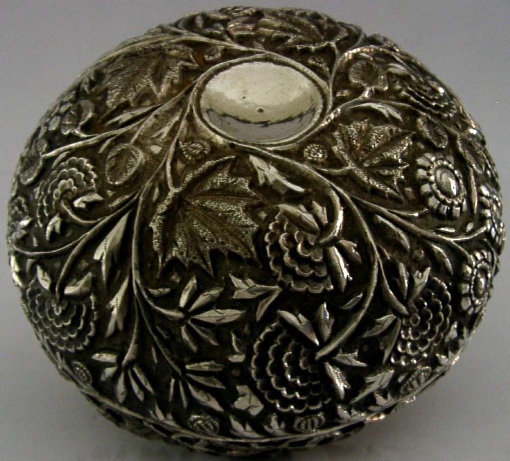 A rounded solid silver bowl featuring detailed repousse floral and foliate hand-chased decoration with a circular central polished medallion. View IV