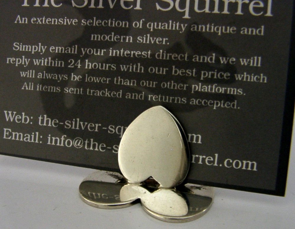 An Edwardian sterling silver menu holder featuring a heart-shaped slotted clip set upon a heart-shaped flat base. View IV