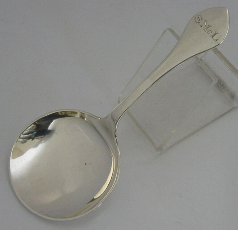 An antique sterling silver caddy spoon featuring a rounded shallow bowl and a tapered handle with engraved initials. View III