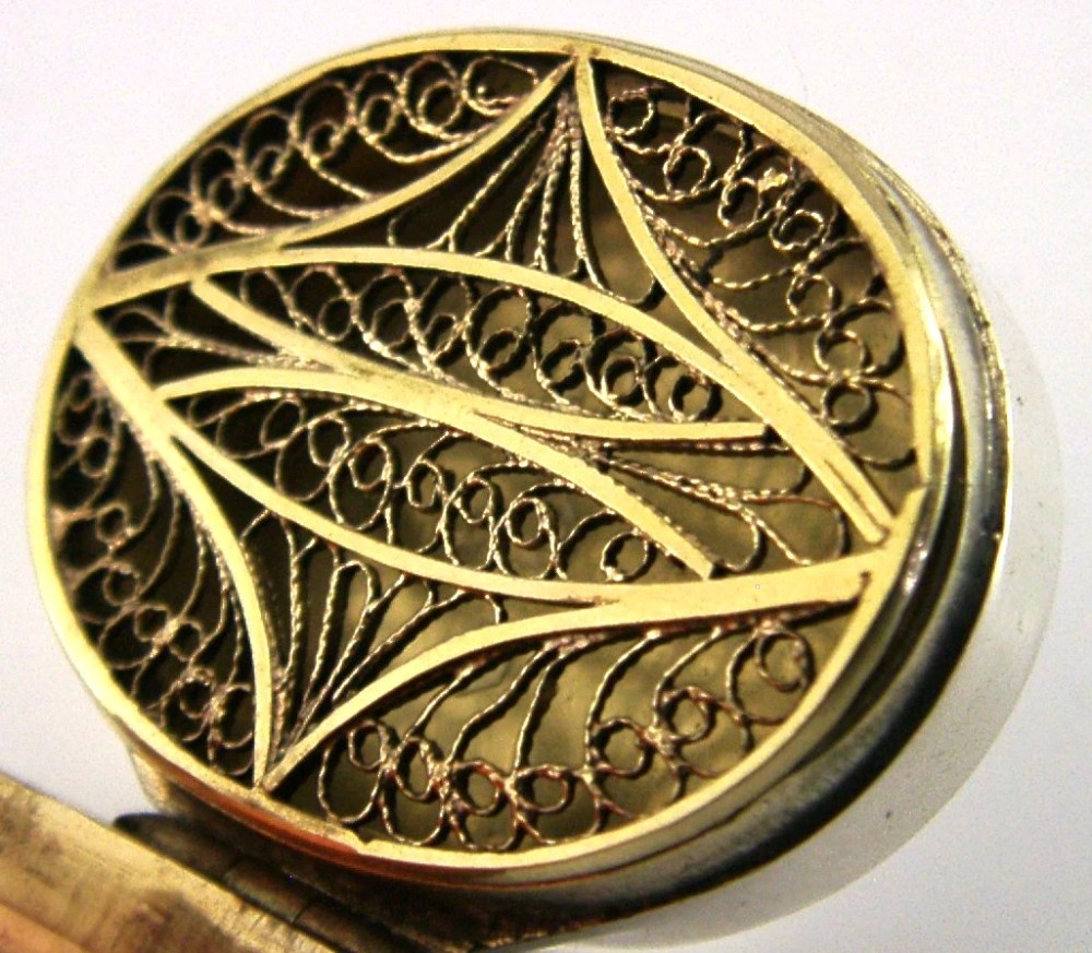 An oval Georgian sterling silver vinaigrette box shown open to reveal an orange agate inset lid and an articulated filigree inner grille. View IV
