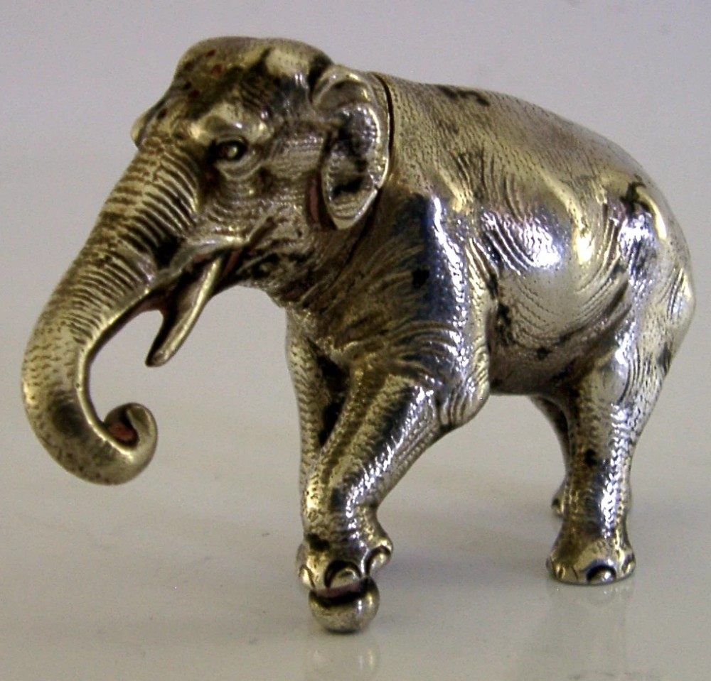 A detailed solid silver pounce box sculpted in the realistic shape of an elephant with a curved trunk.
