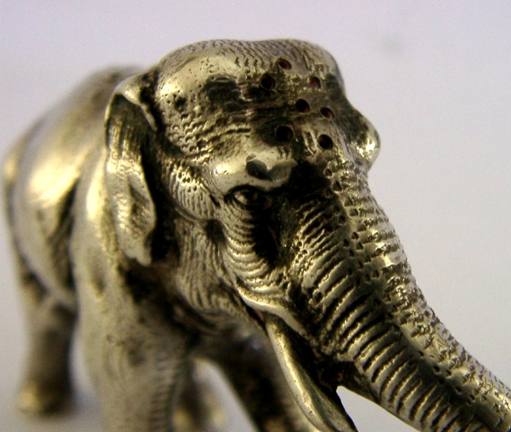 A detailed solid silver pounce box sculpted in the realistic shape of an elephant with a curved trunk. View III