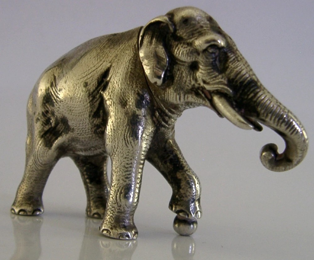 A detailed solid silver pounce box sculpted in the realistic shape of an elephant with a curved trunk. View VII