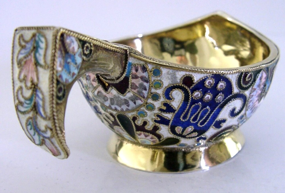 An antique boat-shaped Russian silver-gilt kovsh decorated with polychrome cloisonne enamel floral scrollwork and a gold-plated interior.