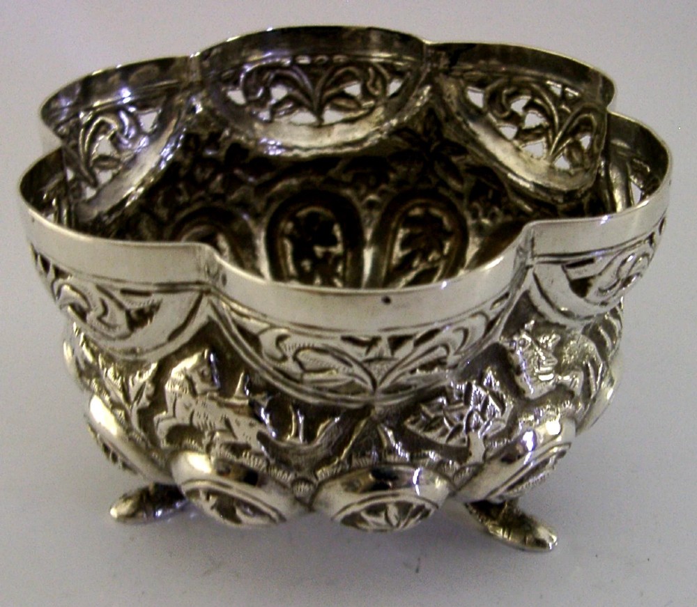 A small footed solid silver bowl featuring intricate repousse floral and animal motifs with a scalloped rim. View III
