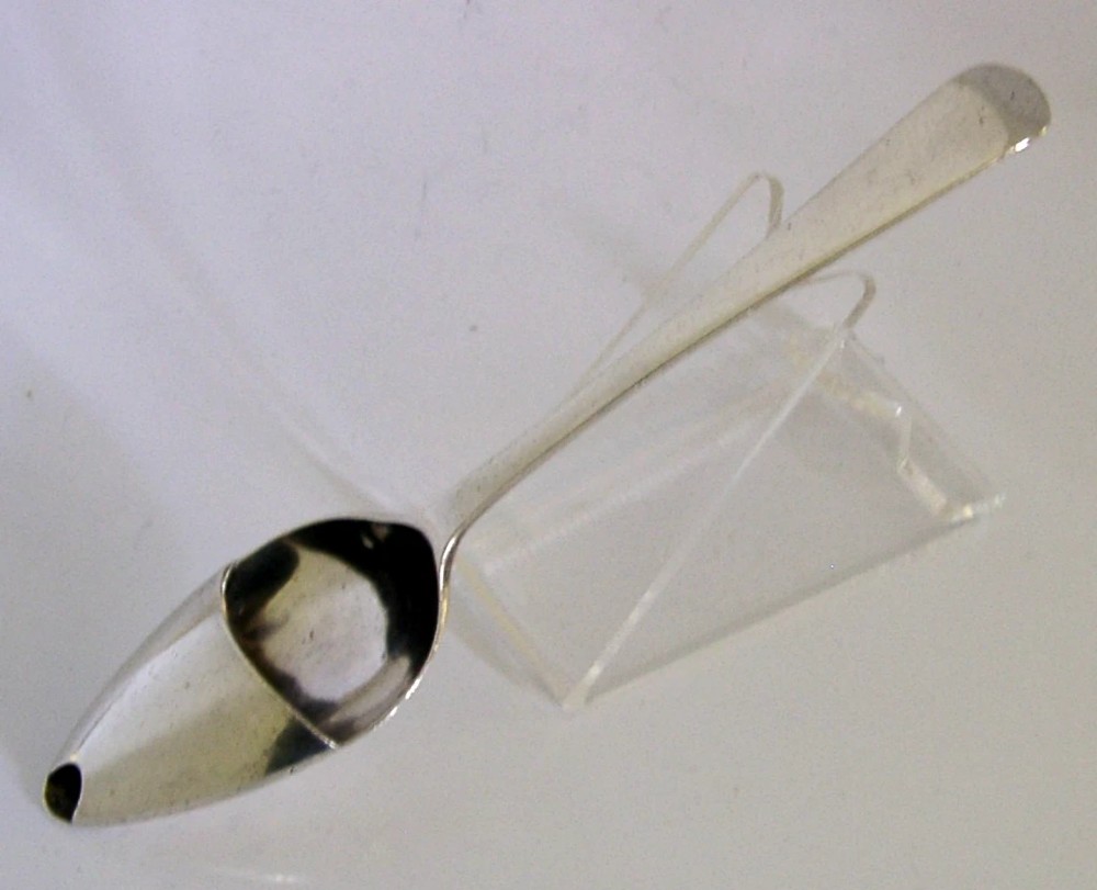 An antique sterling silver medicine spoon featuring a tapered handle and a partially covered bowl with a pouring spout. View III