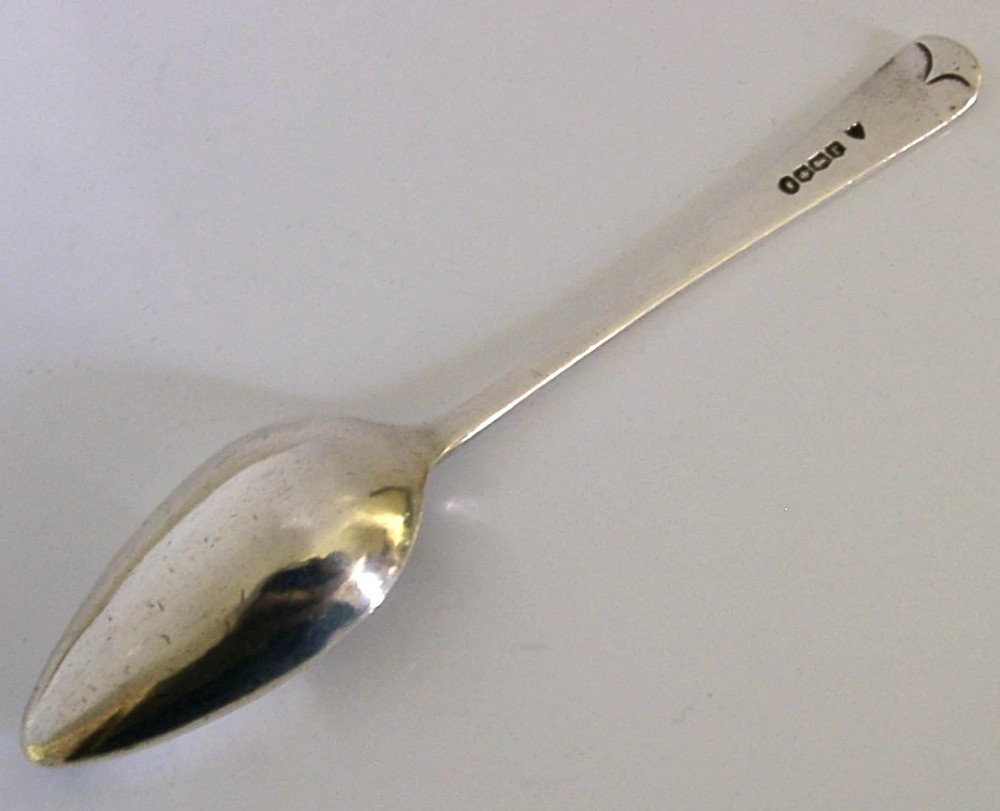 An antique sterling silver medicine spoon featuring a tapered handle and a partially covered bowl with a pouring spout. View IV