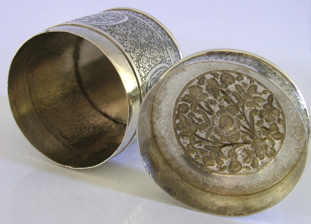 A cylindrical solid silver tea caddy featuring intricate chased floral and bird designs with a pierced pattern top lid. View IX