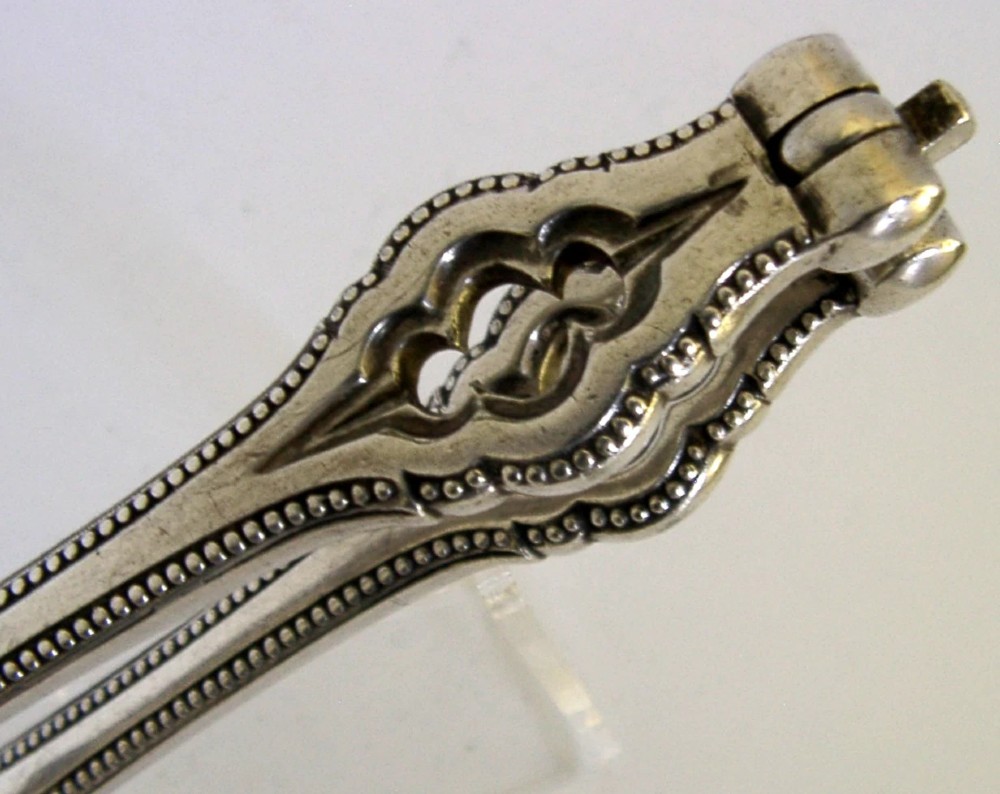A pair of Victorian silver-plated nutcrackers featuring Gothic tracery motifs, beaded edges, and stamped maker hallmarks along the handle. View II