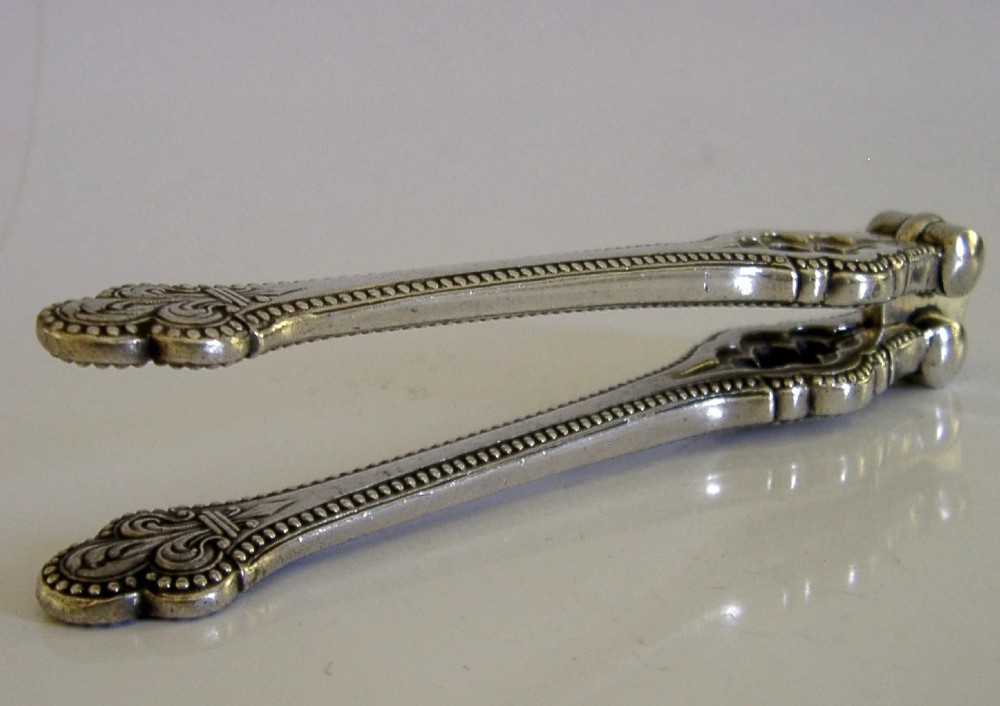 A pair of Victorian silver-plated nutcrackers featuring Gothic tracery motifs, beaded edges, and stamped maker hallmarks along the handle. View III