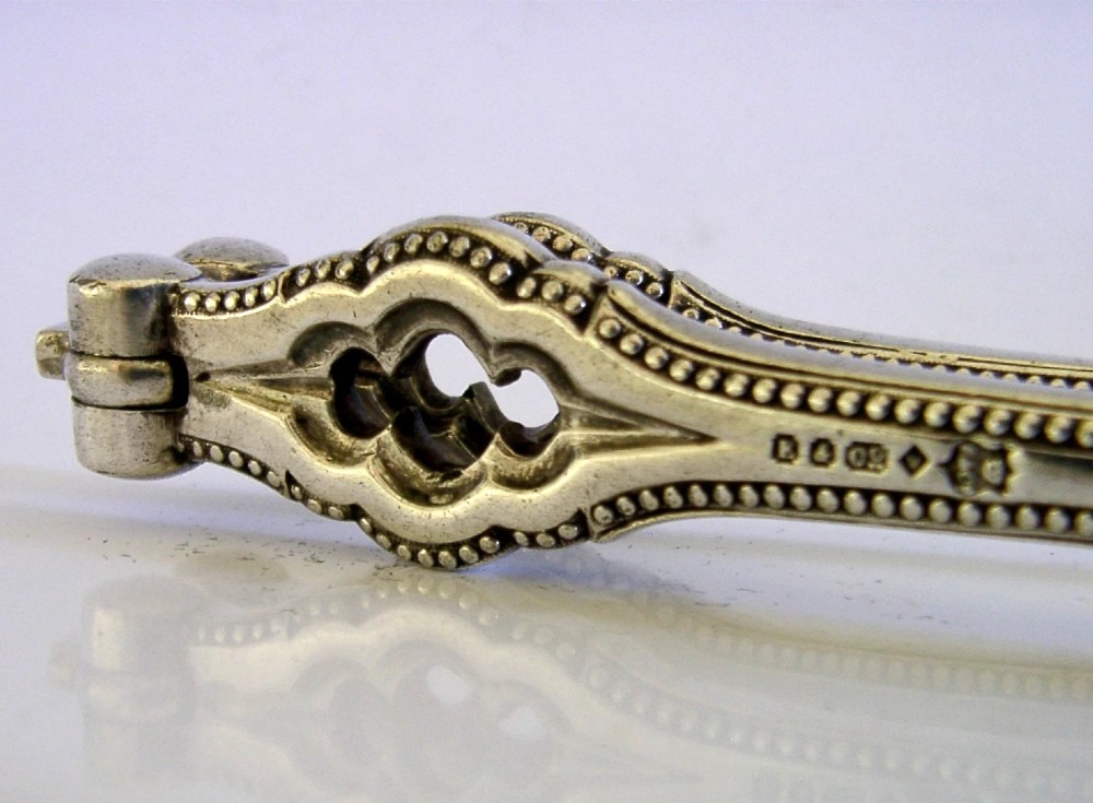 A pair of Victorian silver-plated nutcrackers featuring Gothic tracery motifs, beaded edges, and stamped maker hallmarks along the handle. View IV