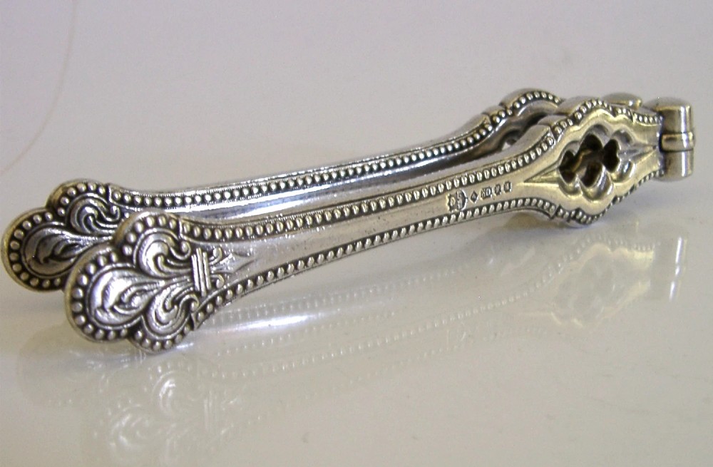 A pair of Victorian silver-plated nutcrackers featuring Gothic tracery motifs, beaded edges, and stamped maker hallmarks along the handle. View V