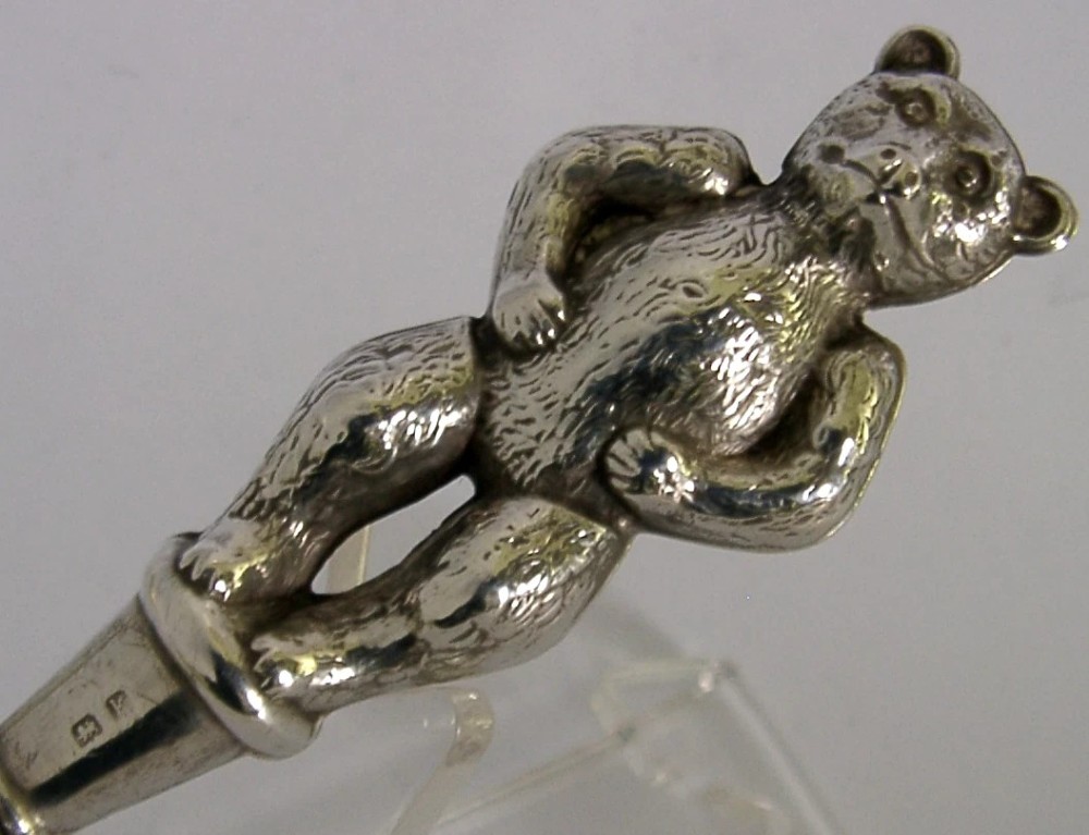 An Edwardian sterling silver button hook featuring a figurative teddy bear handle connected to a long steel shaft. View II