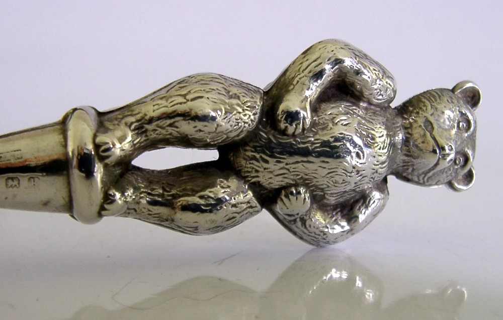 An Edwardian sterling silver button hook featuring a figurative teddy bear handle connected to a long steel shaft. View III