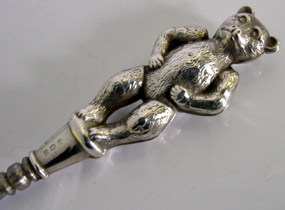 An Edwardian sterling silver button hook featuring a figurative teddy bear handle connected to a long steel shaft. View VII