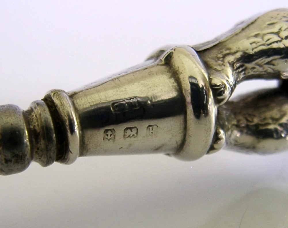 An Edwardian sterling silver button hook featuring a figurative teddy bear handle connected to a long steel shaft. View VIII