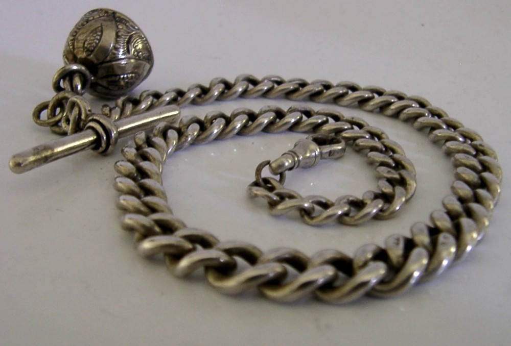 An Edwardian sterling silver curb-link pocket watch chain featuring a T-bar, swivel clip, and an engraved dome-shaped seal fob. View II