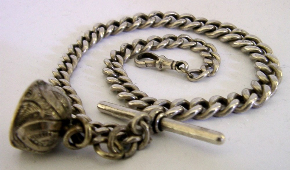 An Edwardian sterling silver curb-link pocket watch chain featuring a T-bar, swivel clip, and an engraved dome-shaped seal fob. View VI