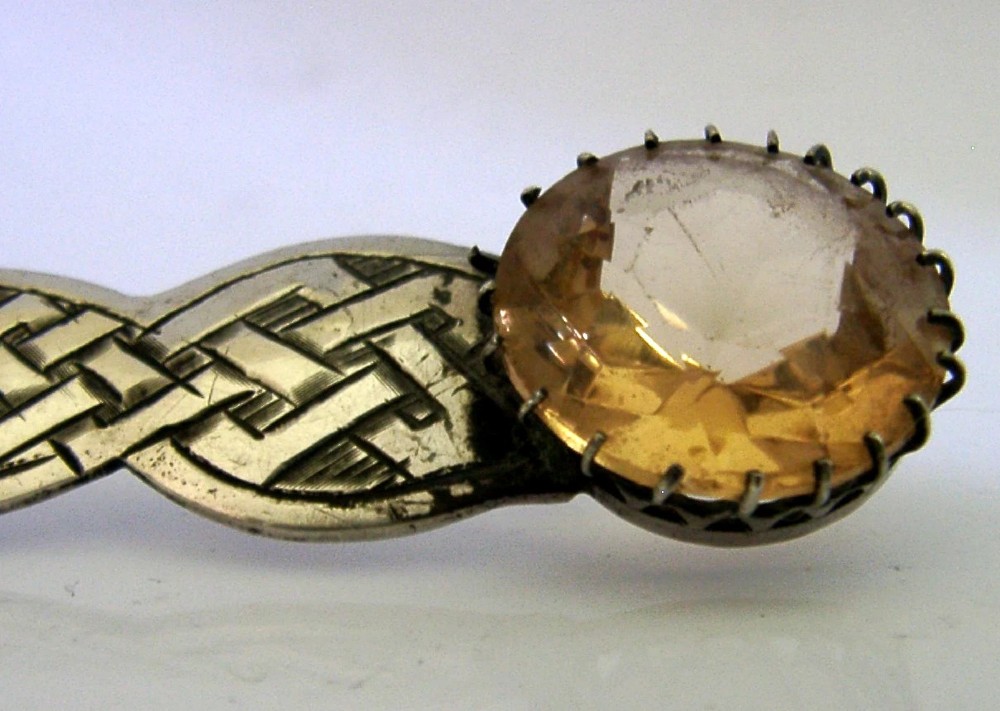 A Scottish sterling silver letter opener featuring Celtic interlace carving and an amber-toned citrine gem on the handle. View II