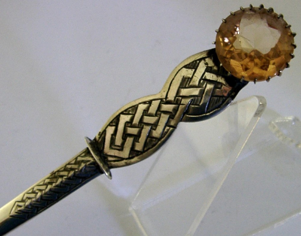 A Scottish sterling silver letter opener featuring Celtic interlace carving and an amber-toned citrine gem on the handle. View IV