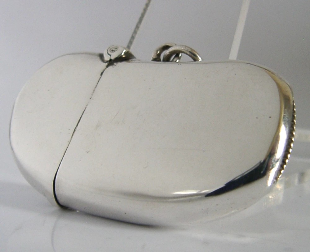 An Edwardian sterling silver kidney bean shaped vesta case featuring a hinged lid and suspension ring. View III