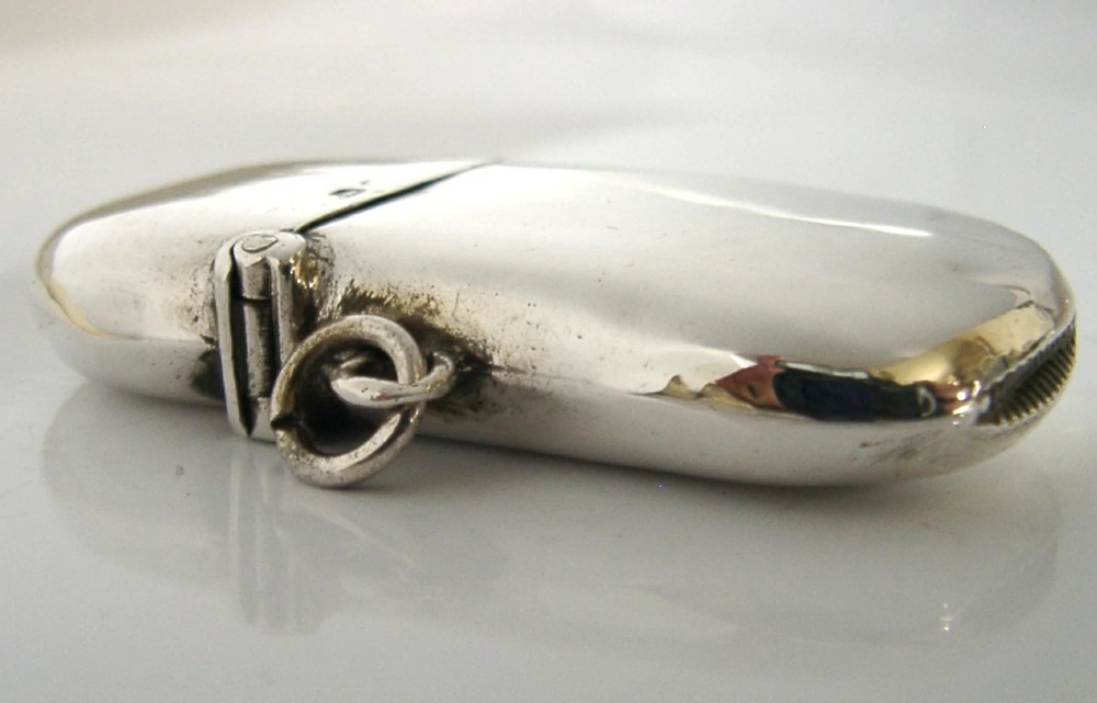 An Edwardian sterling silver kidney bean shaped vesta case featuring a hinged lid and suspension ring. View VI