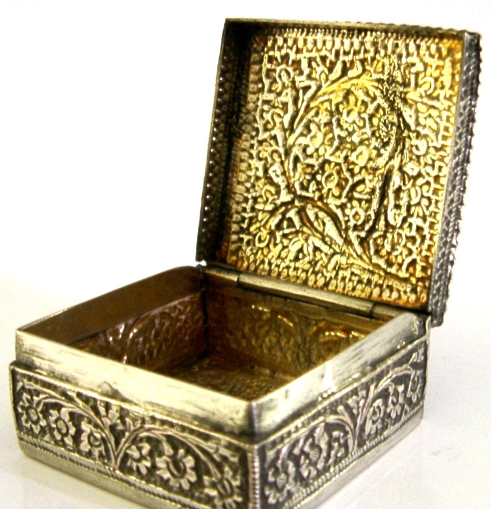 An open square solid silver box featuring detailed floral scroll repousse work across its exterior surface. View II