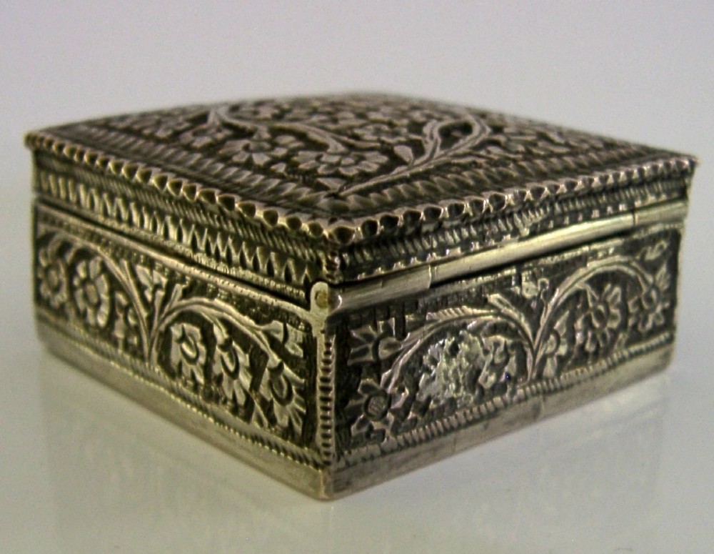 An open square solid silver box featuring detailed floral scroll repousse work across its exterior surface. View IV