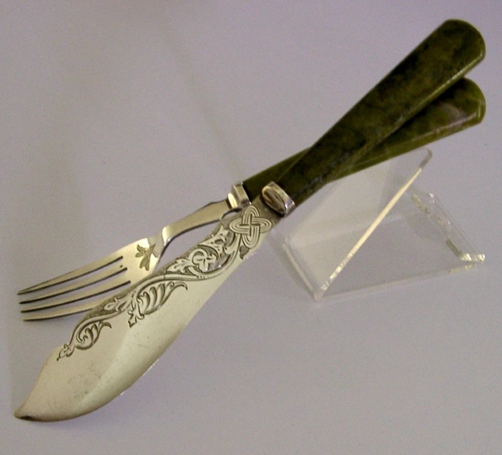 An antique silver-plated fish knife and fork set featuring engraved Celtic knotwork and smooth green marble handles. View V