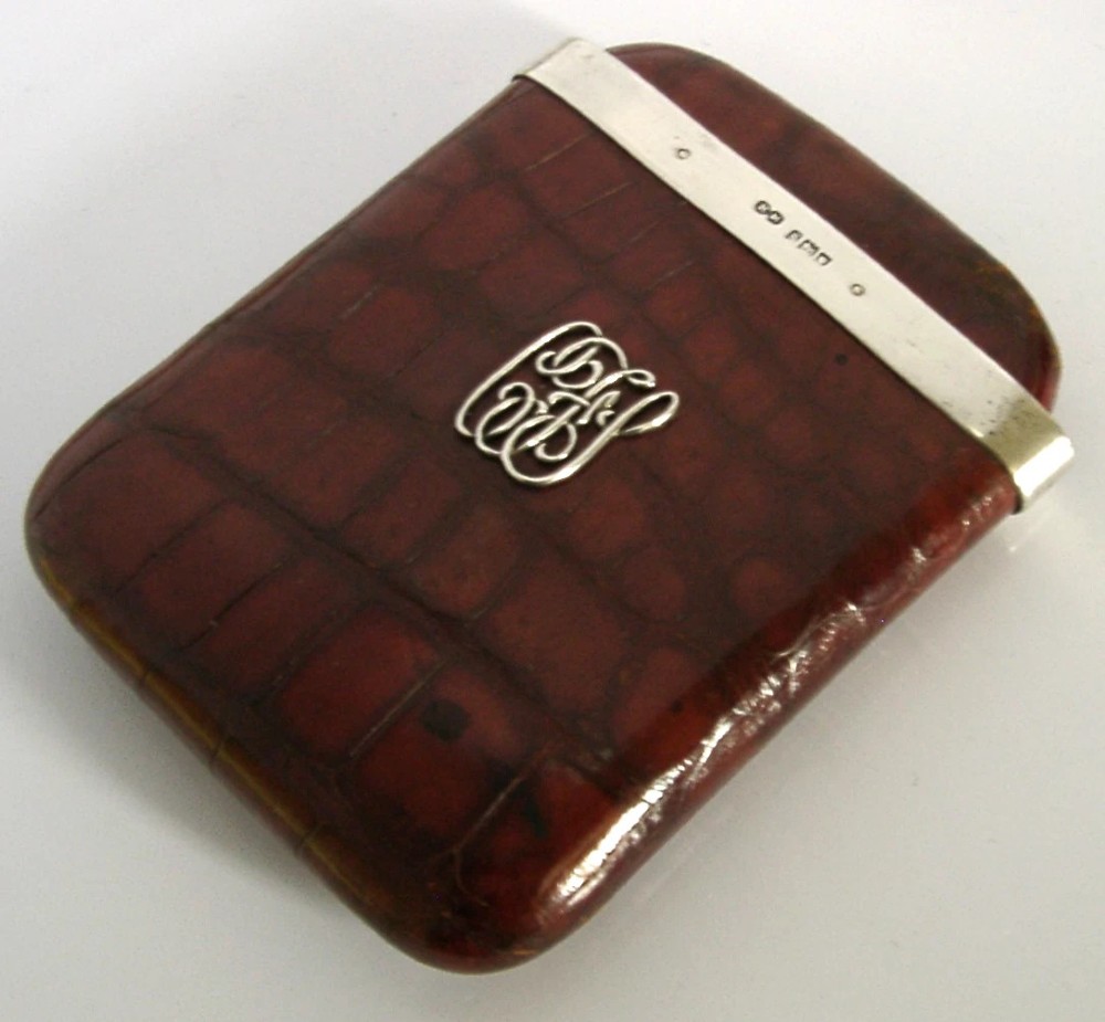 An Edwardian reddish-brown crocodile leather cigar case featuring a sterling silver hallmarked band at the top and an applied silver monogram on the front. View II