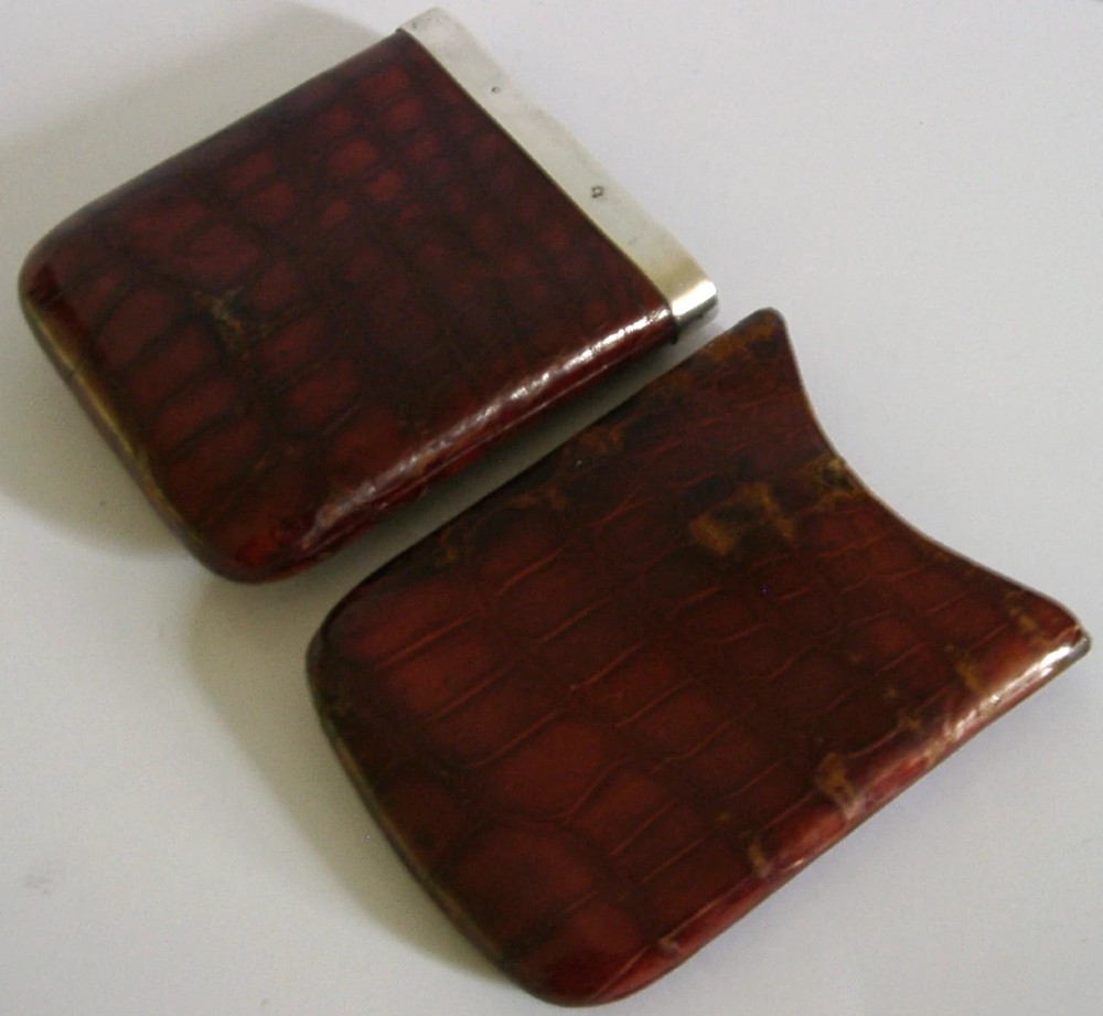 An Edwardian reddish-brown crocodile leather cigar case featuring a sterling silver hallmarked band at the top and an applied silver monogram on the front. View V