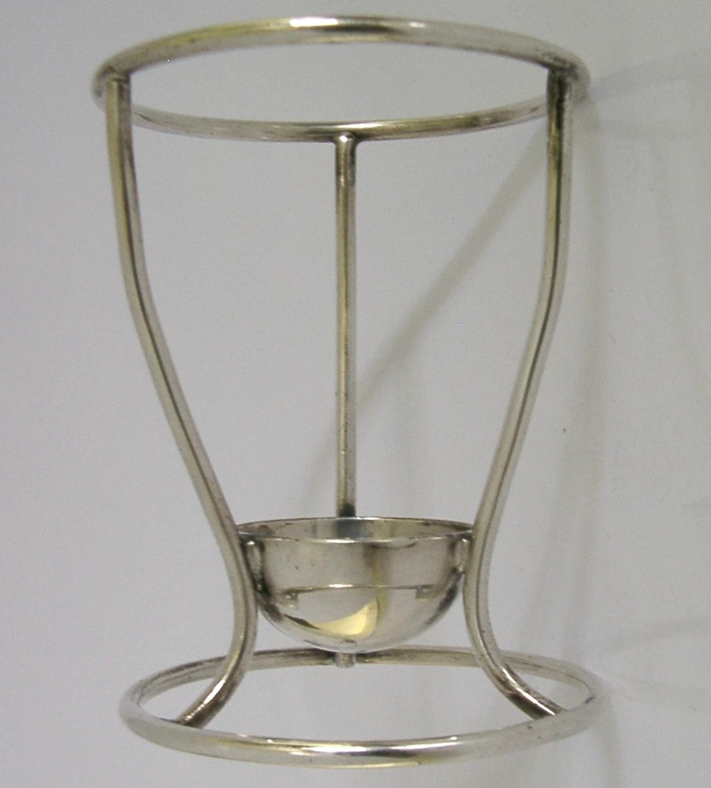 A Victorian silver-plated wirework stand designed to hold a Hamilton torpedo bottle, featuring a circular base, curved uprights, a top ring, and a central cup. View II