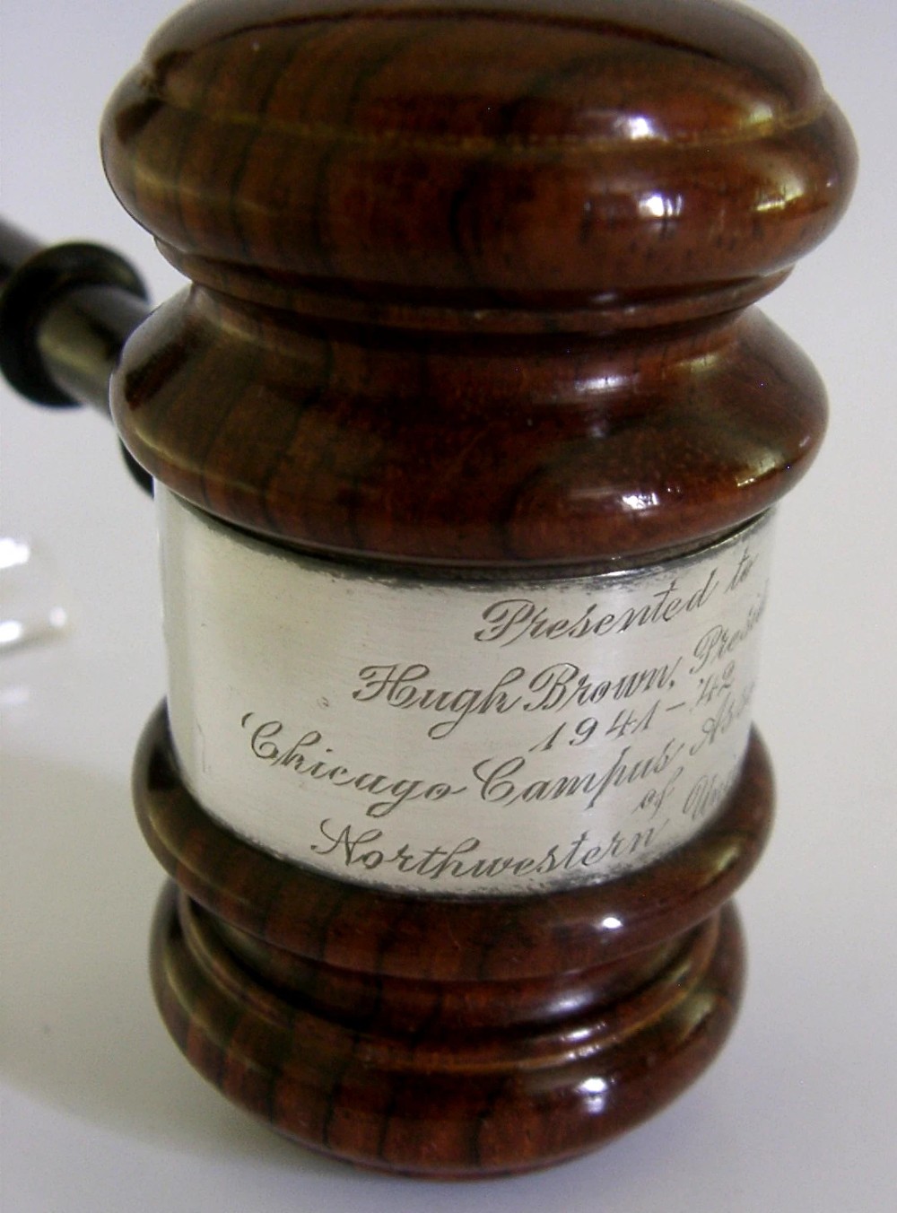 A turned dark hardwood gavel featuring a central sterling silver collar with engraved presentation text. View V