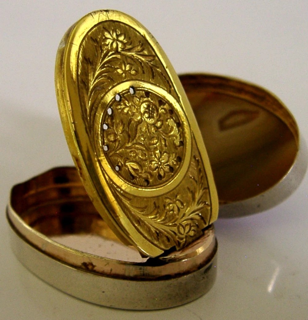 An open Georgian silver oval vinaigrette box featuring a translucent banded agate lid insert and a perforated gold-gilded floral inner grille. View VII