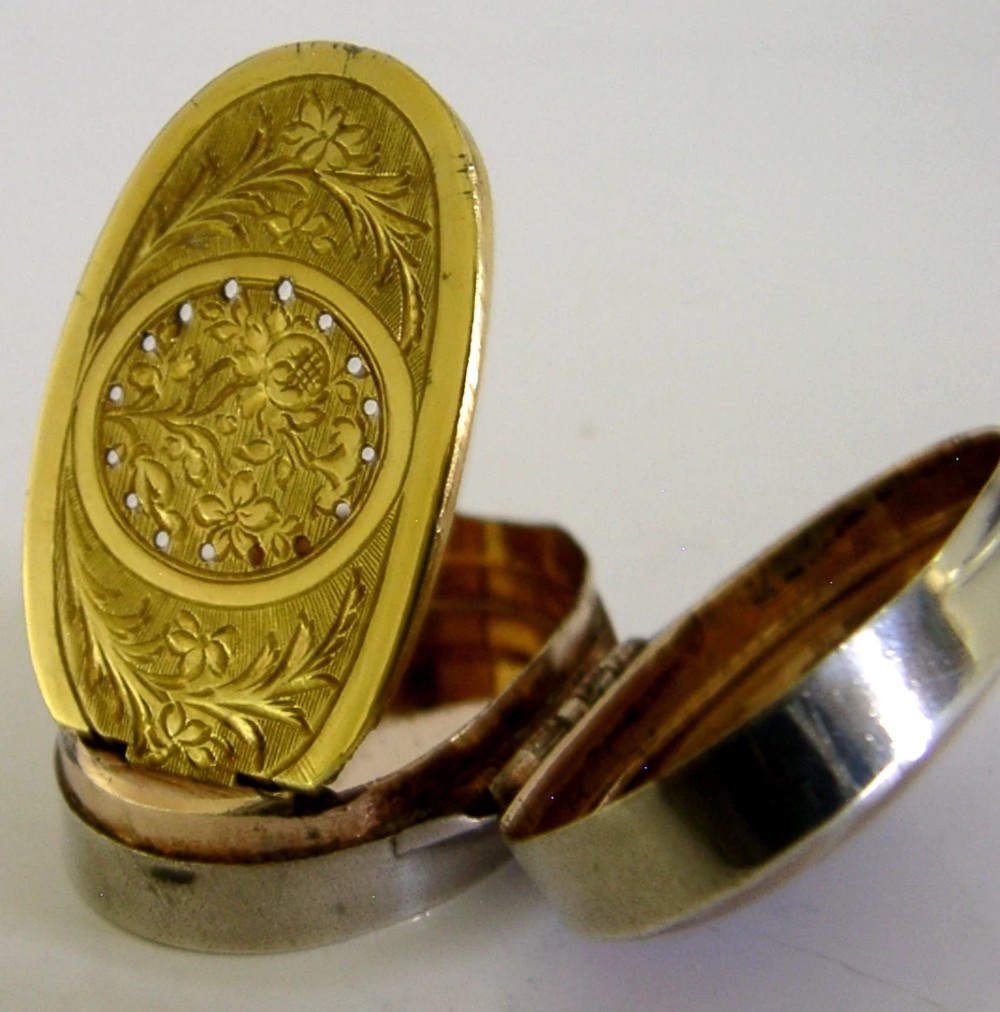 An open Georgian silver oval vinaigrette box featuring a translucent banded agate lid insert and a perforated gold-gilded floral inner grille. View VIII