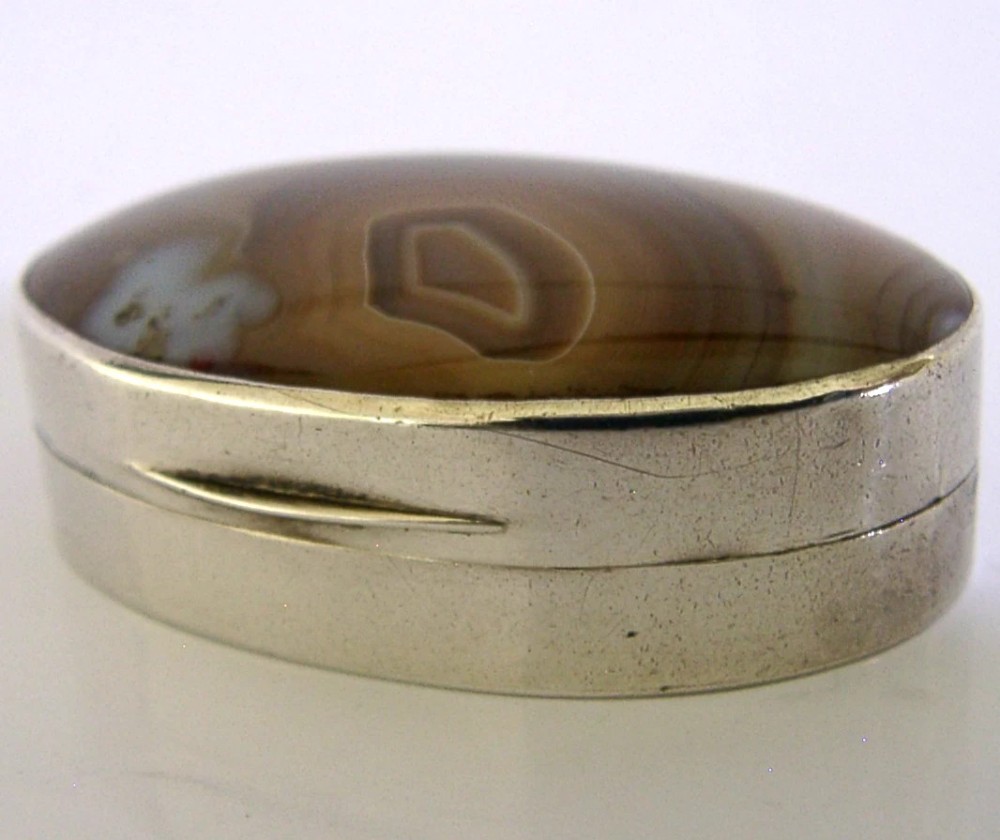 An open Georgian silver oval vinaigrette box featuring a translucent banded agate lid insert and a perforated gold-gilded floral inner grille. View IX