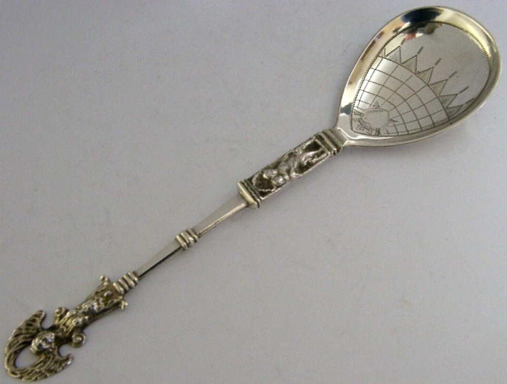 An antique Norwegian 830 silver baptism spoon featuring an engraved drop-shaped bowl and a detailed cast decorative handle.