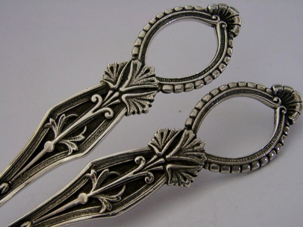 A pair of English sterling silver grape shears featuring Gothic relief carving on the handles and a central floral pivot. View II