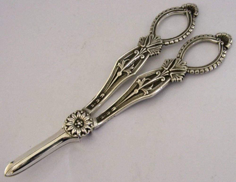 A pair of English sterling silver grape shears featuring Gothic relief carving on the handles and a central floral pivot. View III