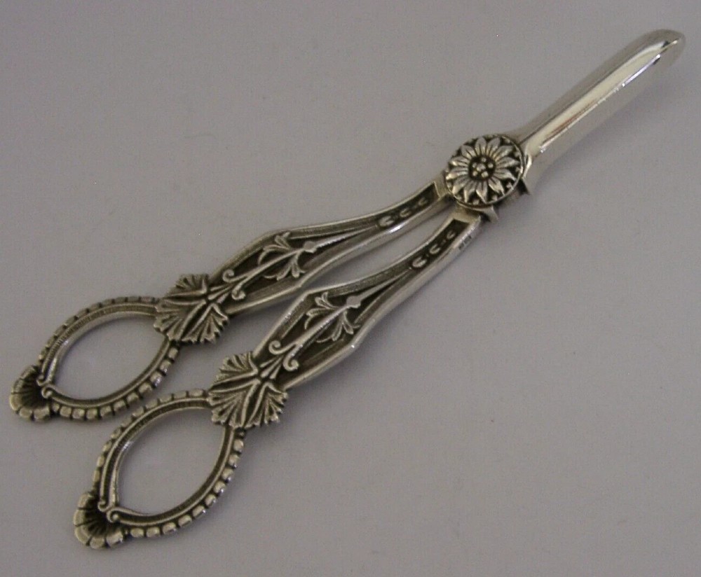 A pair of English sterling silver grape shears featuring Gothic relief carving on the handles and a central floral pivot. View IV