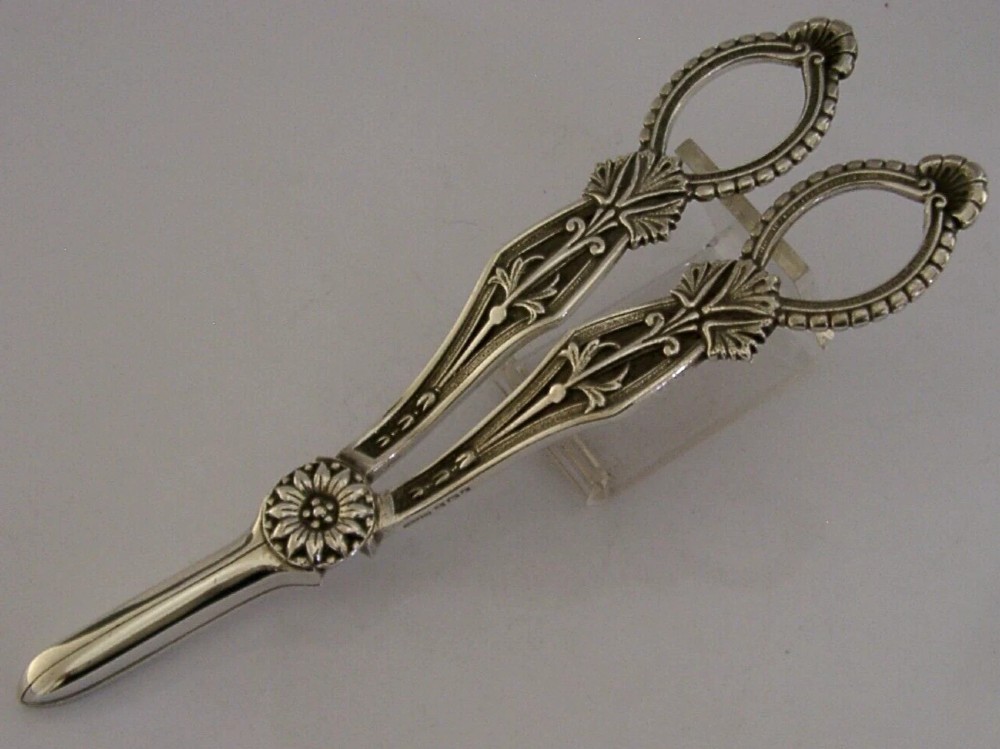 A pair of English sterling silver grape shears featuring Gothic relief carving on the handles and a central floral pivot. View VI