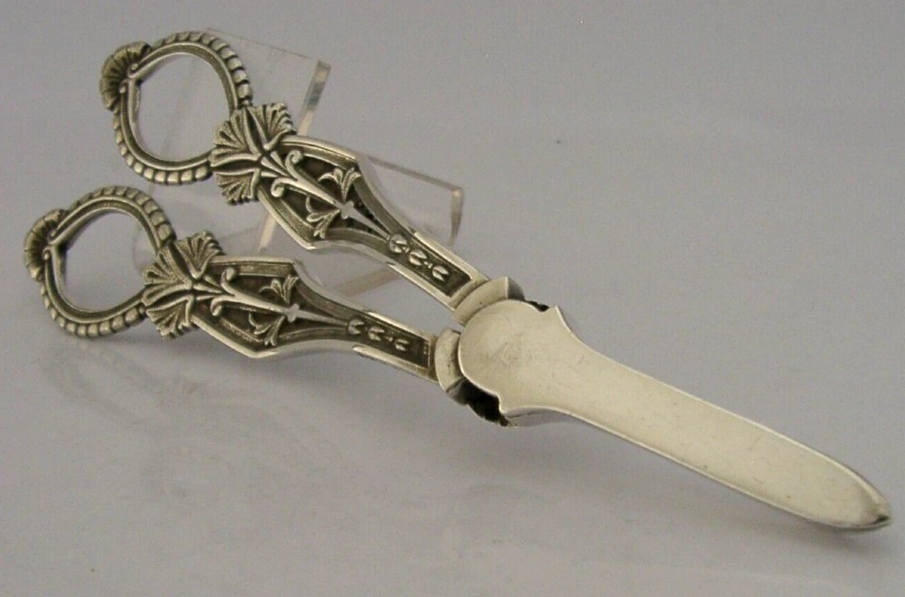 A pair of English sterling silver grape shears featuring Gothic relief carving on the handles and a central floral pivot. View IX