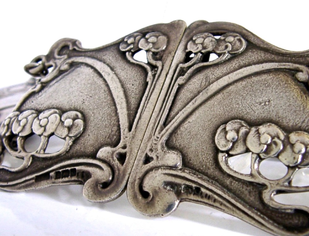 An antique Art Nouveau sterling silver linked waist belt featuring intricate floral panels and a central interlocking buckle. View II