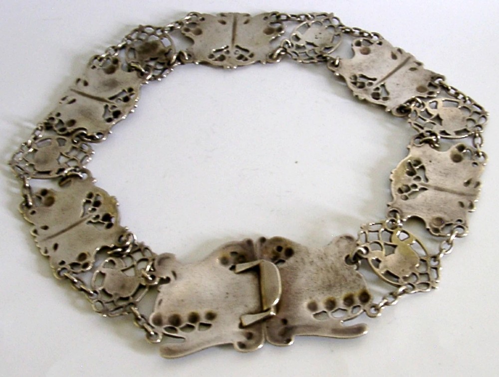 An antique Art Nouveau sterling silver linked waist belt featuring intricate floral panels and a central interlocking buckle. View VIII