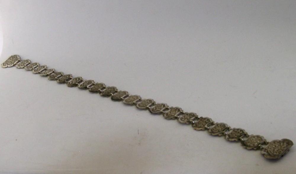 An antique Indian silver belt featuring intricate floral chased link panels and a matching central buckle. View IV