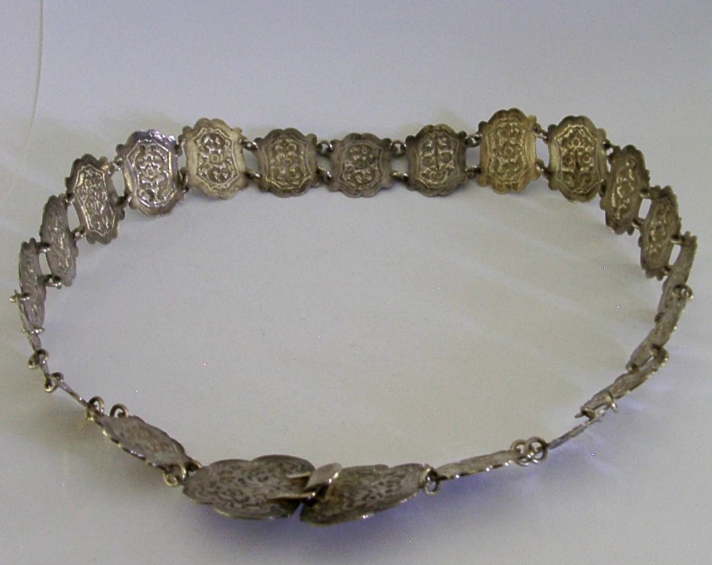 An antique Indian silver belt featuring intricate floral chased link panels and a matching central buckle. View VI