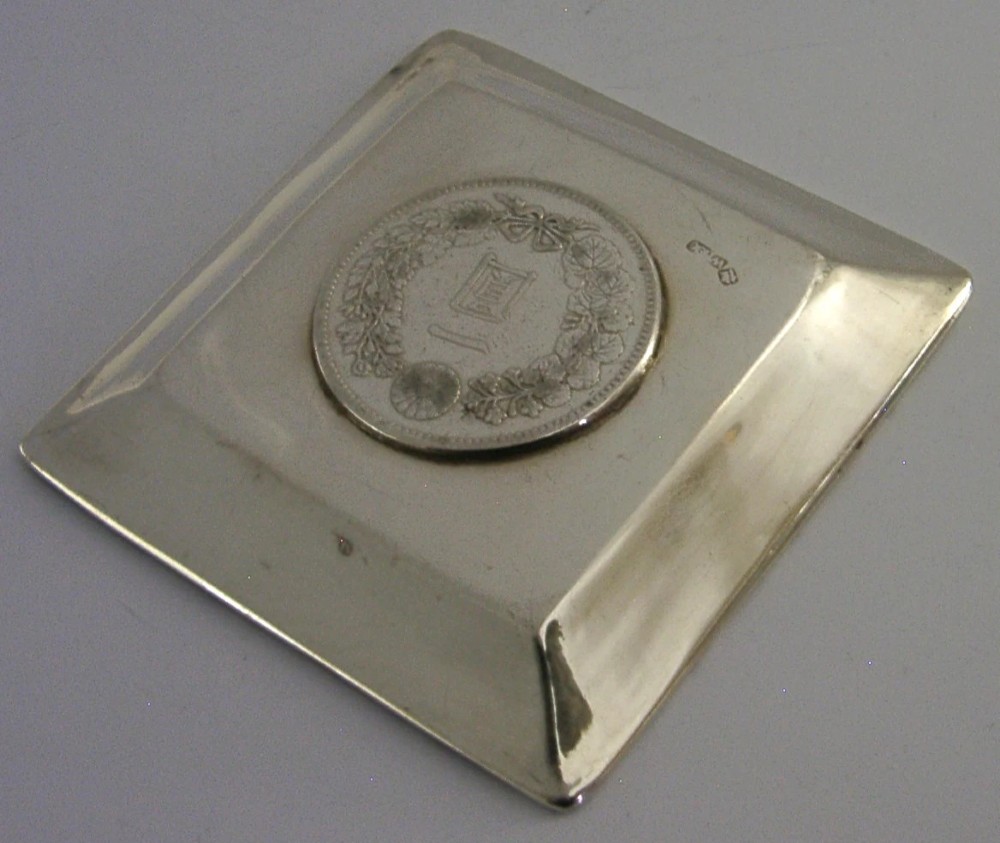 A square sterling silver coin dish featuring a central Japanese One Yen silver coin, hand-hammered interior border, and bamboo-style rim. View V