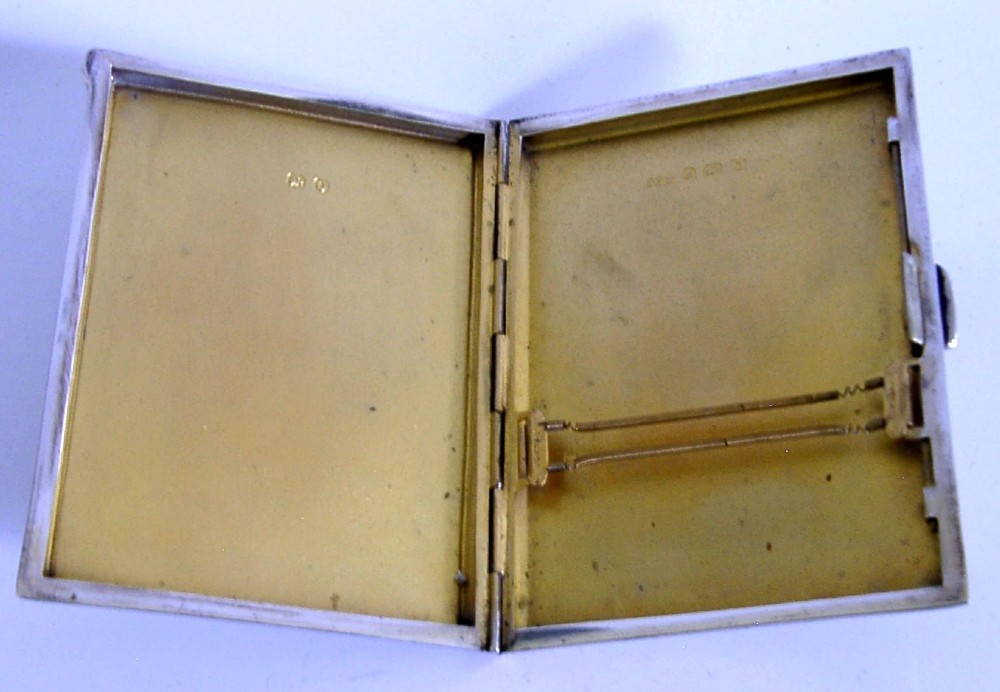 A square sterling silver hinged cigarette case showing an engine-turned textured exterior on one side and a white enamelled panel with hand-painted yellow and pink chrysanthemums on the other. View VIII