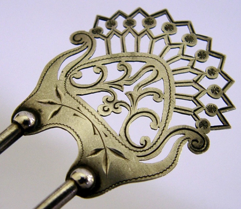 An antique sterling silver two-prong hair slide featuring a fan-shaped pierced crest with scrolling motifs and geometric openwork. View II